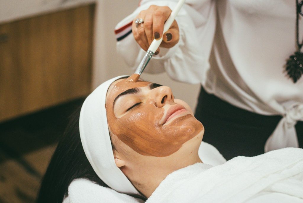 Terapis melakukan face therapy dengan pijatan wajah lembut untuk relaksasi dan kulit cerah di RX Relaxology