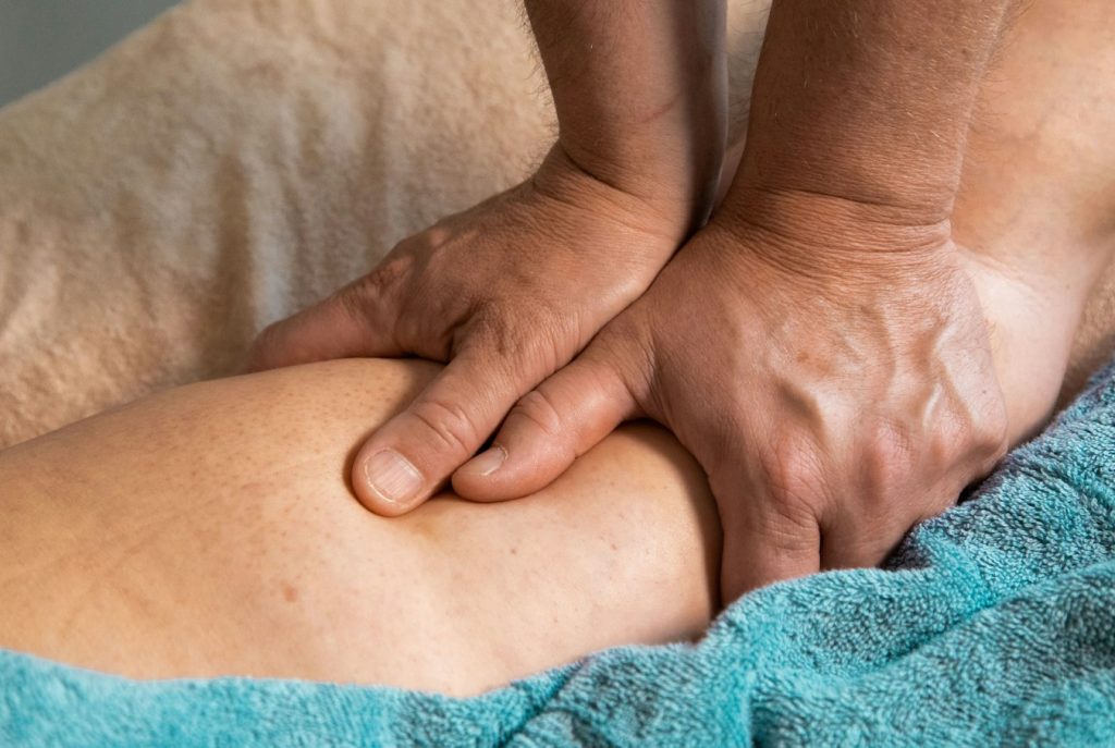 Terapis memijat kaki atlet dengan teknik Sport Massage untuk pemulihan otot di Relaxology