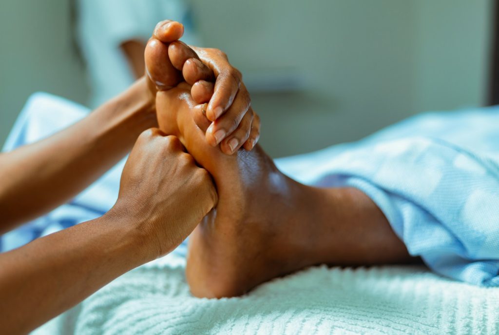 Terapis melakukan pijat refleksi pada telapak kaki sebagai panduan pijat refleksi untuk pemula di Relaxology