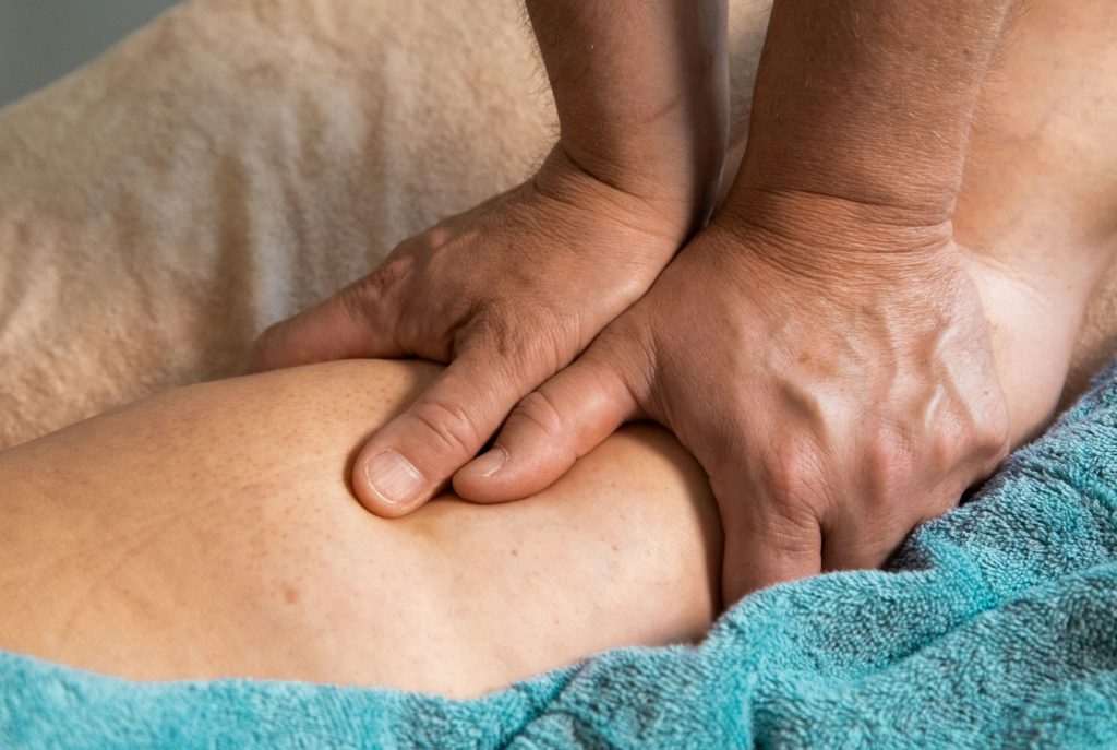 Terapis memijat otot kaki untuk pemulihan setelah olahraga dengan sport massage, thai massage, atau oriental massage di Relaxology